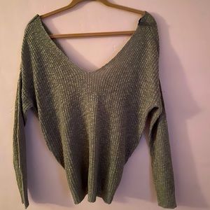 Off the shoulder, open back, green sweater.